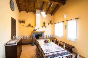 una sala da pranzo con tavolo e camino di Villa del Gelso Chalet nel Parco dellEtna a Mascali