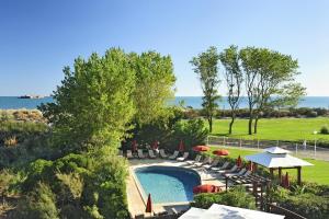 - une vue sur la piscine bordée de chaises et de parasols dans l'établissement CAPAO Beach Hôtel, au Cap d'Agde