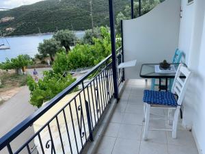 uma varanda com uma mesa e vista para a água em ΜΕΤΑΧΑ em Mikros Gialos