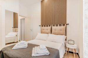 a white bedroom with a large bed with towels on it at Casa Roma B&B in Rome