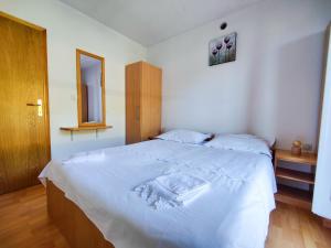 a bedroom with a large white bed with a mirror at Robinson Dionis in Selca kod Bogomolja