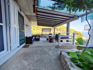 a porch of a house with a view of the ocean at Robinson Dionis in Selca kod Bogomolja