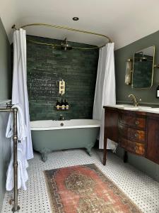 a bathroom with a bath tub and a sink at Cosy Cottage in Lechlade in Lechlade