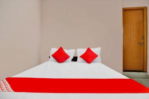- un lit rouge et blanc avec 2 oreillers rouges dans l'établissement SPOT ON Cks Lodge, à Hassan