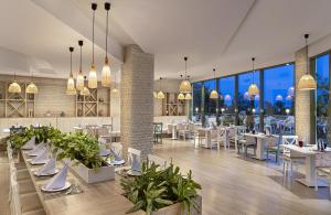 a restaurant with white tables and chairs and large windows at Kaya Side in Side
