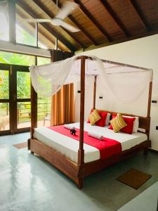 a bedroom with a bed with a canopy at Mango Tree House in Udawalawe