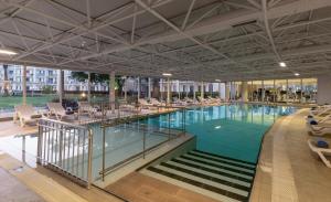 a large swimming pool with lounge chairs in a building at Kaya Side in Side