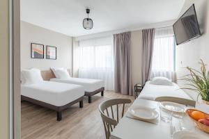 um quarto de hotel com duas camas e uma mesa em Appart'City Classic Bordeaux Centre em Bordeaux