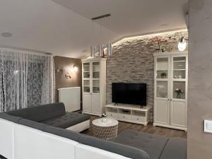 a living room with a couch and a television at Exclusive apartment in Supetarska Draga