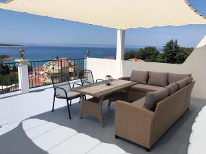 a patio with a table and chairs and an umbrella at Exclusive apartment in Supetarska Draga