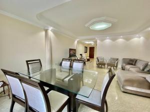 Un comedor con una mesa de cristal y sillas. en A201 - Vista Mar | 3 Quartos c/ Wifi e Churrasqueira, en Samaritá