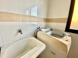 un baño con lavabo y bañera en A201 - Vista Mar | 3 Quartos c/ Wifi e Churrasqueira, en Samaritá 24 fotos más
