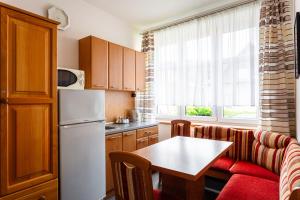 uma cozinha com um sofá, uma mesa e um frigorífico em Penzion na Smetance em Zlín