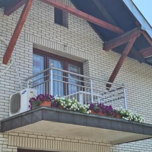 a balcony with flowers on a house at Vila Slavonija 2 in Vrnjačka Banja