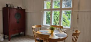 ein Esszimmer mit einem Tisch, Stühlen und Fenstern in der Unterkunft Kleines Landhaus am Wald Bad Saarow in Bad Saarow