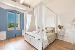 um quarto com uma cama de dossel e uma janela em Masseria Santella Luxury B&B em Cassano delle Murge