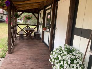 a porch of a house with a table and flowers at Domek u Franka in Smołdzino