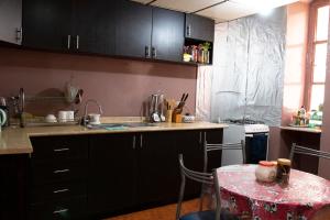 una cocina con armarios negros y una mesa con mantel en Hostal Carlos Luis, en Quito