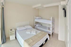 um quarto com 2 camas e um beliche em Pousada Nascer do Sol em Penha