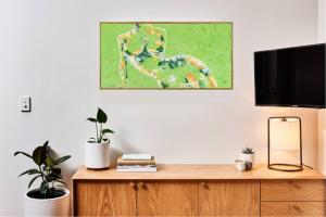 a tv on top of a wooden dresser with plants at Romantic Getaway - 2 luxe outdoor baths in Mount Macedon