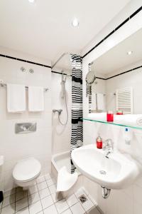 a white bathroom with a sink and a toilet at Hotel Esplanade in Cologne