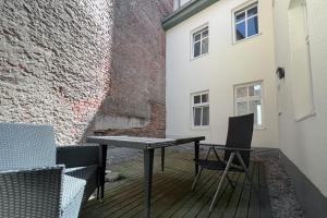uma mesa e cadeiras numa varanda com uma parede de tijolos em NeuWerk em Erfurt
