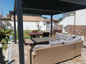 a patio with a table and chairs under a pergola at Villa Vita - Monolocale con giardino in Acilia