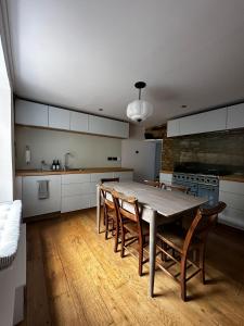 eine Küche mit einem Holztisch und Stühlen in der Unterkunft Cosy Cottage in Lechlade in Lechlade