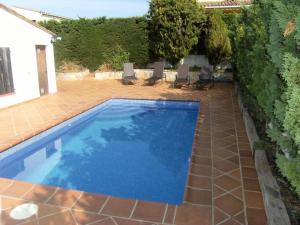 ein Pool in einem Garten mit Stühlen um ihn herum in der Unterkunft Casita Rosa in L'Estartit