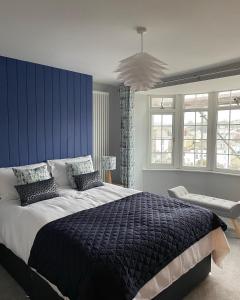 um quarto com uma cama grande e uma parede azul em Number Eleven, Brixham em Brixham