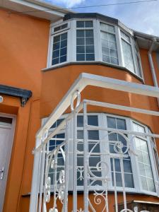 an orange house with a balcony with a gate at Number Eleven, Brixham in Brixham