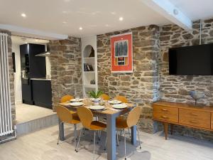 a dining room with a table with chairs and a tv at Number Eleven, Brixham in Brixham