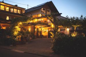 ein beleuchtetes Haus mit Lichtern davor in der Unterkunft Weingut Knodt-Trossen in Kröv