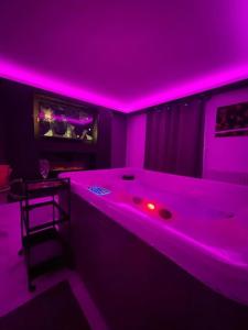 a purple room with a bed with a bar in it at La Suite Casa Dé lové 2.0 jacuzzi & cinema privé in Melun +36 photos