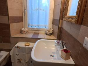 bagno con lavandino, servizi igienici e finestra di Casa Luci d'Alba a Monzambano