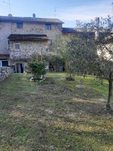 a stone house with an apple tree in front of it at Casa Luci d'Alba in Monzambano