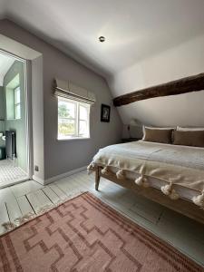 a bedroom with a large bed and a window at Cosy Cottage in Lechlade in Lechlade