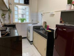 a kitchen with a sink and a stove top oven at Dominos 1 BHK Apartment, Near Carter Road by Connket Homes in Mumbai