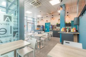 um restaurante de fast food com mesas e cadeiras em Appart'City Classic Bordeaux Centre em Bordeaux