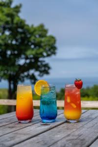 a group of four cocktails sitting on a wooden table at Watermouth Lodges in Ilfracombe