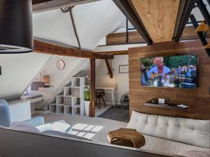 a living room with a tv on a wall at Hotel Hohlebach Mühle in Homberg