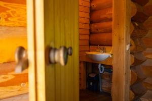 uma casa de banho num chalé de madeira com um lavatório em Crossline Lodge em Gheorgheni