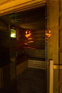 uma sauna com uma porta de vidro num quarto em Crossline Lodge em Gheorgheni
