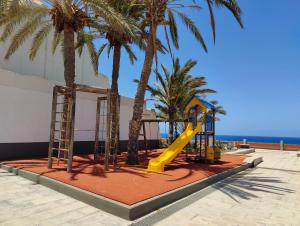 plac zabaw z palmami i zjeżdżalnią w obiekcie MARAVILLA Suite 140 m2 - 3 Bedrooms, Heated Pool w mieście Costa Del Silencio