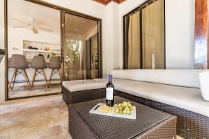a bottle of wine and grapes on a table in a room at Hermosa Palms Casa 23B -3BD - Bruno Casalvolone in Jacó