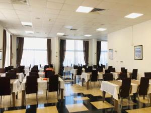 キレニアにあるPark Palace Hotelのテーブルと椅子と窓のあるダイニングルーム +46枚の写真