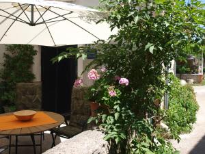 uma mesa com um guarda-chuva e uma árvore com flores em Apartment Krnica N43 em Krnica