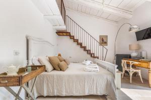um quarto branco com uma cama e uma escada em Masseria Santella Luxury B&B em Cassano delle Murge