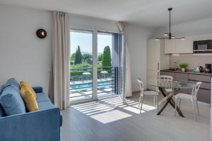 a living room with a blue couch and a glass table at Oleandro Holiday Apartments in Bardolino