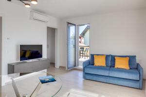 バルドリーノにあるOleandro Holiday Apartmentsのリビングルーム(青いソファ、ガラスのテーブル付)